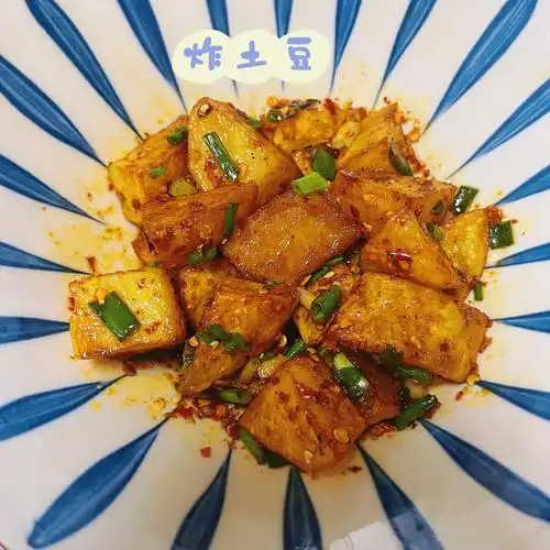 材料:土豆,葱花做法:锅里倒油烧热后放入土豆炸至金黄捞出,土豆放在碗