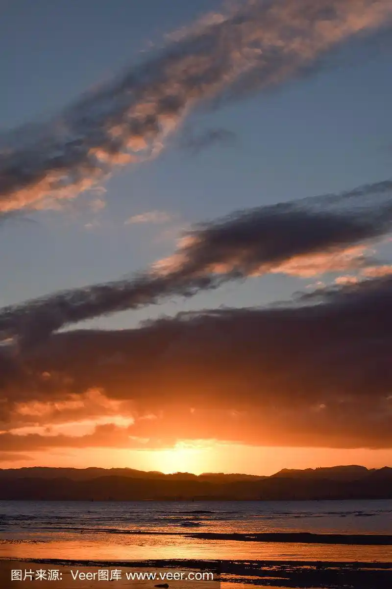 在新西兰吉斯伯恩,夕阳镶在昏暗的天空中.