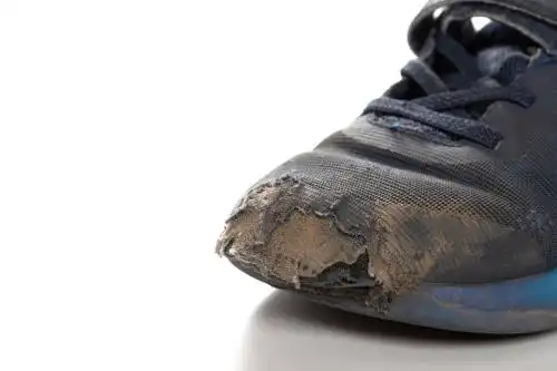 白背景上的破旧儿童运动鞋鞋头特写