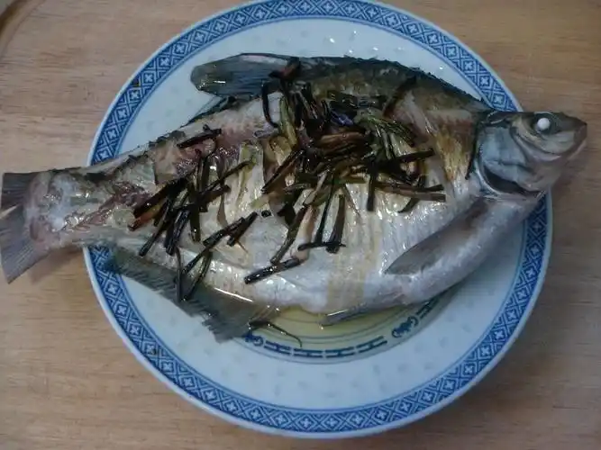 把煎葱的油和葱一起浇在鳊鱼的上面,就完成了,可以上桌子.