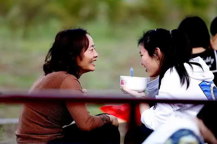 2018年4月2日,安徽省毛坦厂镇金安中学门口,陪读妈妈给孩子送晚餐.