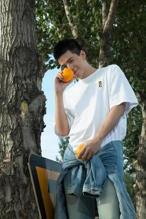 林柏睿秋日晒照路边食甜橙 白t牛仔裤画面清新