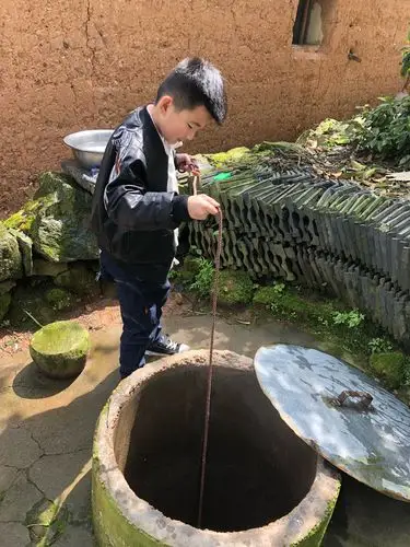 妈妈看见村里有一口水井,问我会不会打水,我前面刚看一个爷爷用过,便