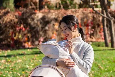 年轻的母亲抱着襁褓婴儿照片