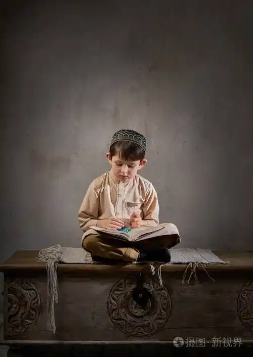 穆斯林小男孩带着念珠读着古兰经祈祷真主斋月kareem概念儿童精神和平