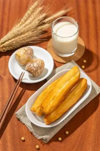 中国传统早餐豆浆油条茶叶蛋特写木桌面背景