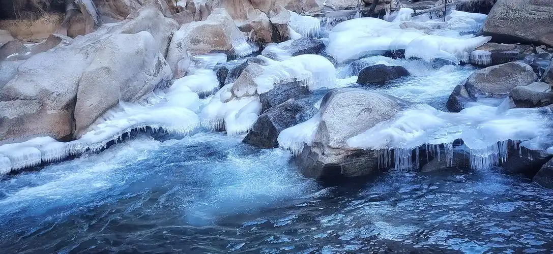 帕米尔高原的冬天河水结冰冰河下面水继续流淌冰河和水的颜色在强烈的