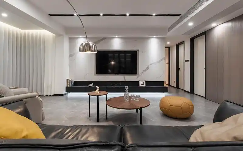 客厅的电视背景墙分为上下两部分,上面是岩板做以电视凹槽,将电视放于