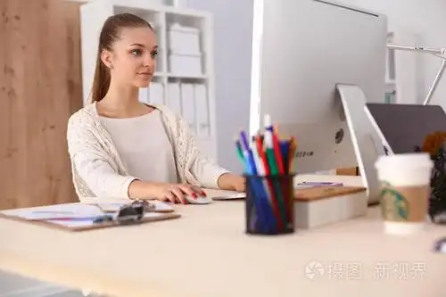 在办公室里,坐在办公桌前工作的年轻女子照片-正版商用图片0y3882-摄