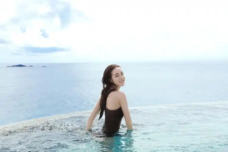 迪丽热巴畅游泳池秀香肩面朝大海回眸一笑