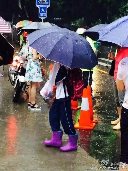 组图:高考第二天广州暴雨 学生赤脚去考场