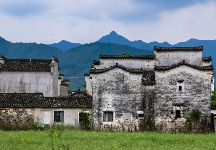 路边徽派民居建筑,马头墙,白色斑驳的墙面,青瓦配青山绿水,赏心悦目.