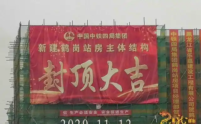 主体结构封顶大吉的红色巨幅",各有关单位的祝贺条幅挂满了主体建筑物