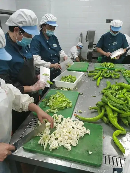 员工们正在对各类菜品进行切配.