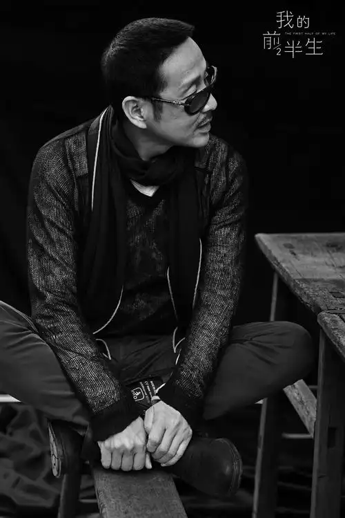 极致黑白色调中,陈道明姿态放松坐在板椅上,高端质感十足.