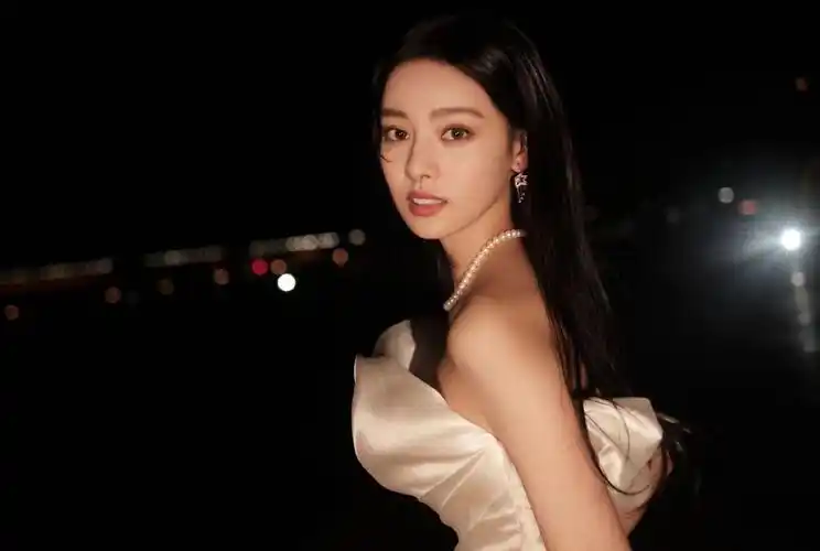 张艺上身穿白色贝壳裙,黑长直长发搭配复古珍珠首饰