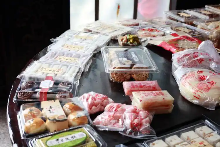 塘栖古镇,广济桥北的朱一堂据说是百年老店买了一块桂花糕给女儿,顺带