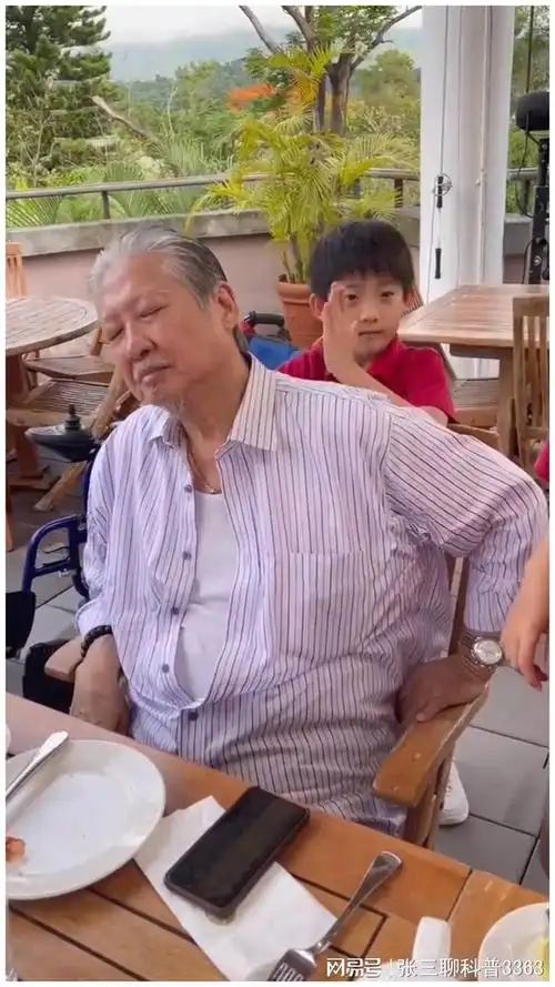 73岁洪金宝坐轮椅现身街头遇断腿乞儿即赠500元