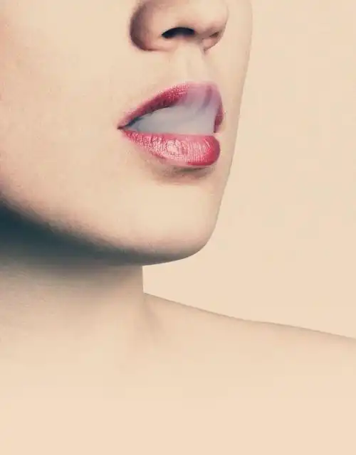 有着完美妆容的美女嘴里冒着烟雾