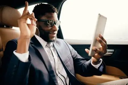 一个开车的男人用他的平板电脑在skype上聊天.照片