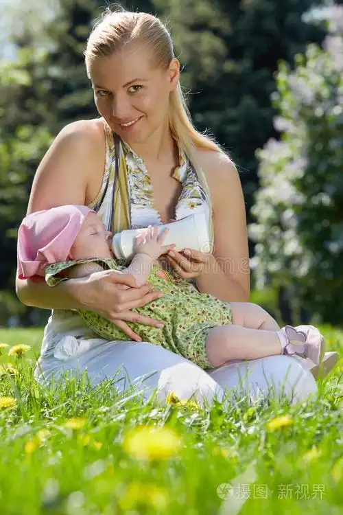 微笑着的年轻母亲给婴儿喂奶照片-正版商用图片0mqt4w-摄图新视界