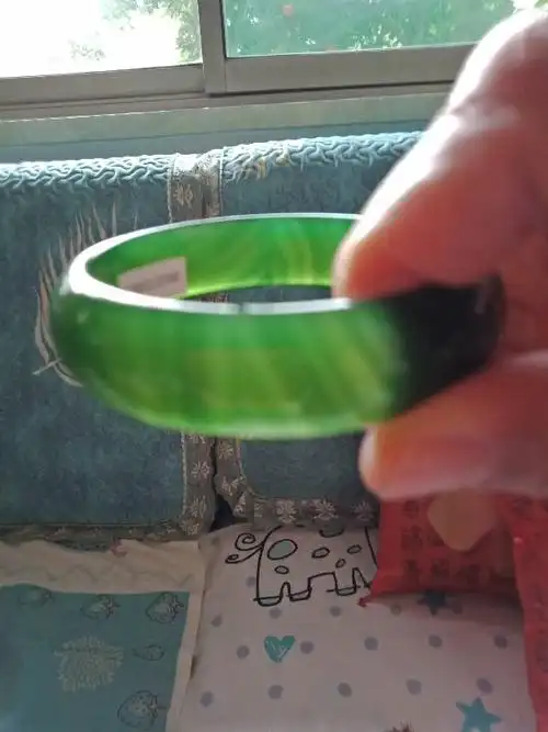 我在西安买了绿玉髓手镯760块钱,在灯下能看到一些条纹,不知真假,专家