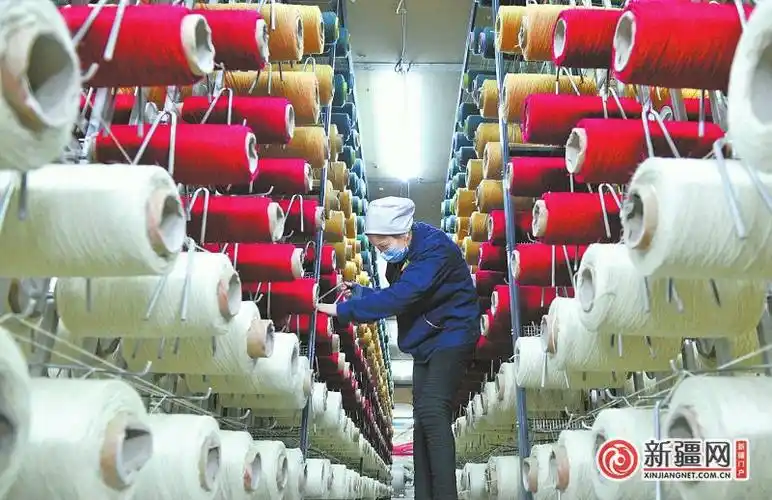 在经开区(头屯河区)帕尔拉克地毯厂生产车间,挡车工在连接地毯纺线.