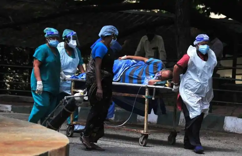 5月24日,医务人员将一名新冠患者送往印度班加罗尔一家医院.