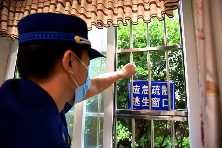 消防救援支队工作人员检查逃生窗口.(摄影:刘琦)