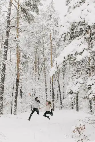 一对相爱的夫妇在雪地森林里拥抱亲吻和享受