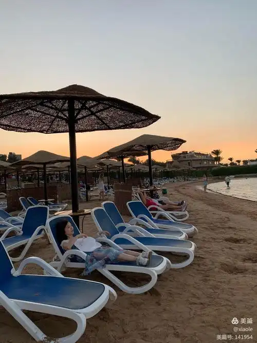 惬意地躺在沙滩椅上观赏天空夕阳及远处点点帆船