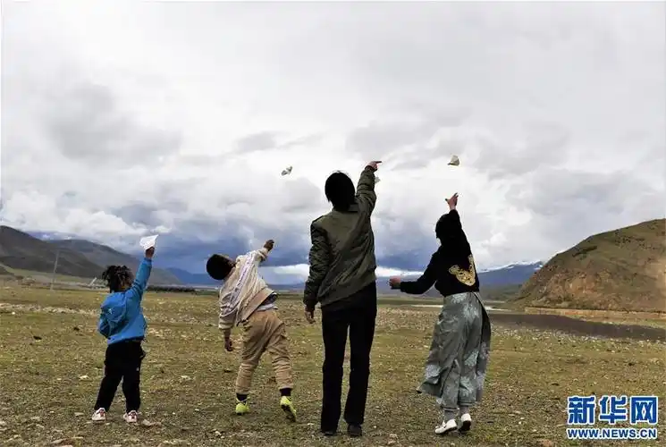 坚热益西(右二)在牧区和弟弟妹妹一起放飞纸飞机(7月13日摄).