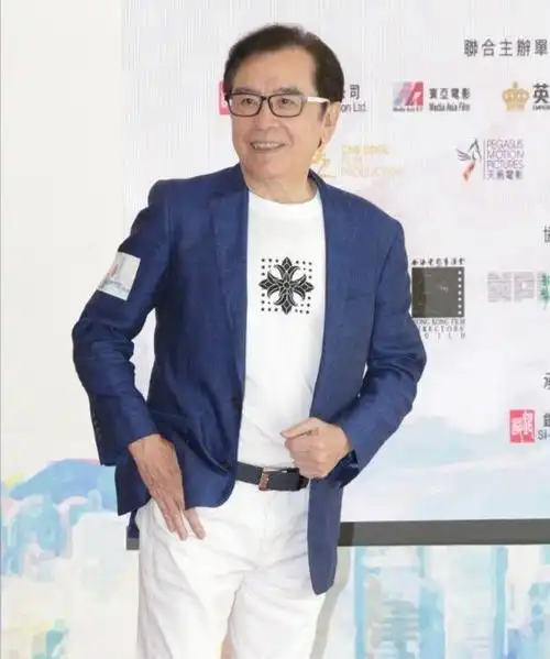 照片中,姜大卫身穿深蓝色西装搭配白色裤子,头发被一丝不苟地梳在一旁