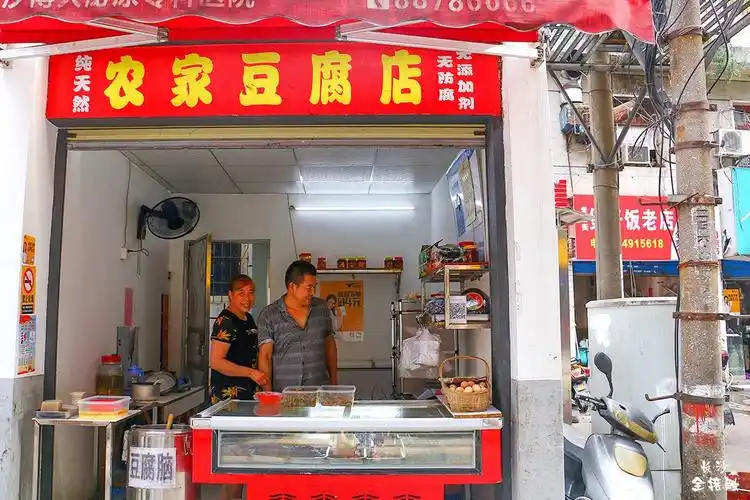 豆腐都是老板自己手工磨的,原汁原味,一整块码在木板子上,有人来要买