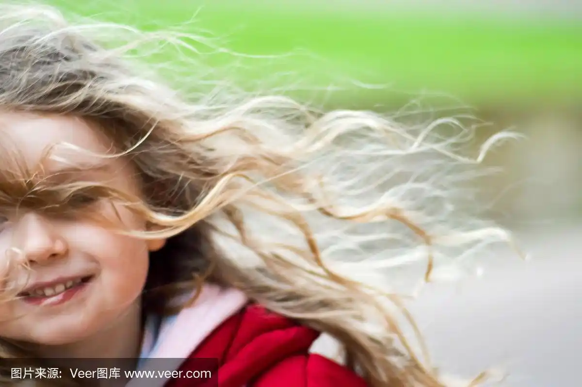 风吹过一个女孩的脸的头发