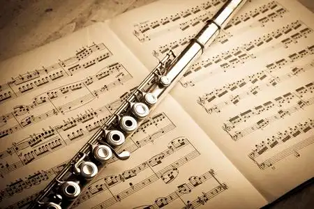 乐谱上的乐队古代音乐积分背景上的银色长笛照片