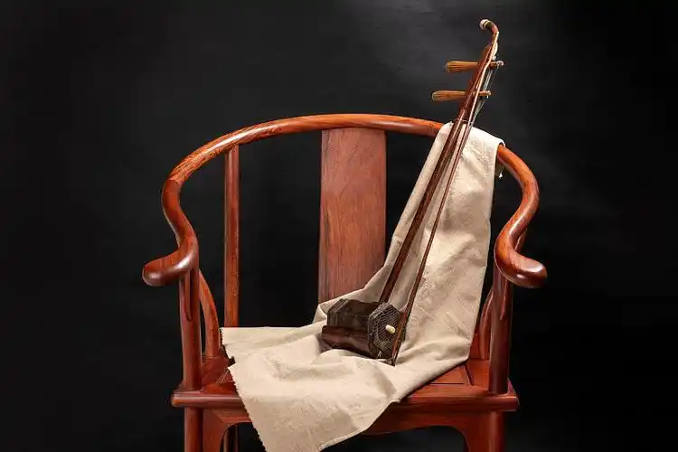 一把二胡放在圈椅上特写深色调照片素材