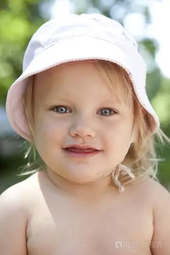 肖像的金发小姑娘用蓝色眼睛戴着巴拿马