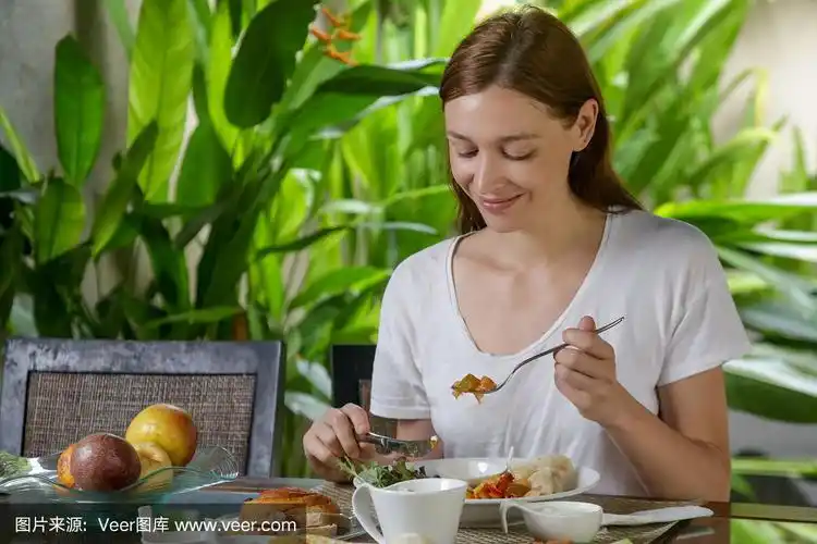 在厨房餐桌上吃饭的女人