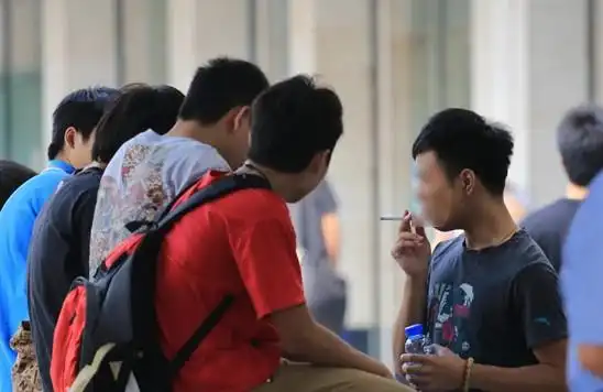 在我国公共场所全面实行禁烟任重道远.图为一烟民正旁若无人地吸烟