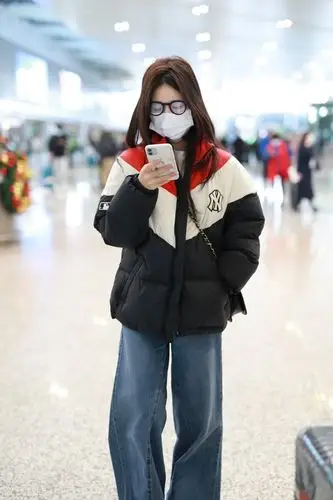 赵露思现身机场只顾低头玩手机,穿搭拼色羽绒服元气满满