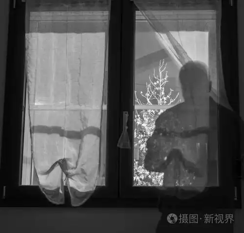 窗户与窗帘和人造光在外面和人的影子在前面