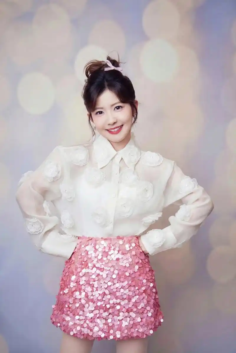 赖美云, 蹲姿俏皮, 笑容甜美, 背景梦幻, 粉嫩搭配, 时尚感十足.