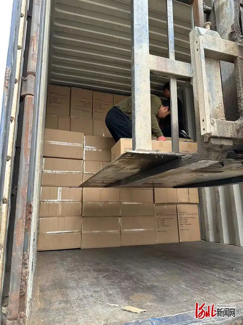 衡水大韩纺织品有限公司的库房外,工人们正将货物搬进集装箱车