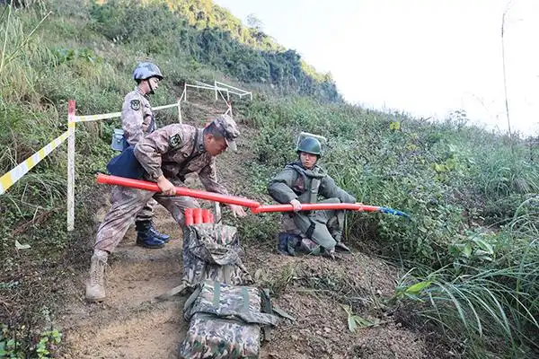 官兵们采用把扫雷爆破筒收尾相接,逐次爆破推进的方式进入雷场.