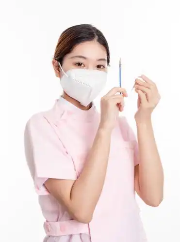 白色背景中的中国年轻女护士在使用注射器