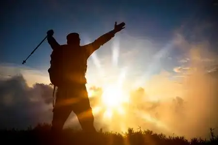 站在山顶看日出的人照片