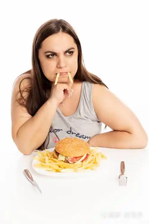 年轻的胖女人吃快餐