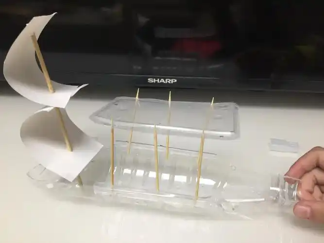 将帆和船蓬各用胶纸固定在矿泉水瓶的尾部和边缘,这样帆船就完成了.