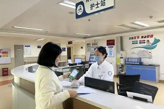 患者家属在骨关节外科护士站办理出院结算手续.